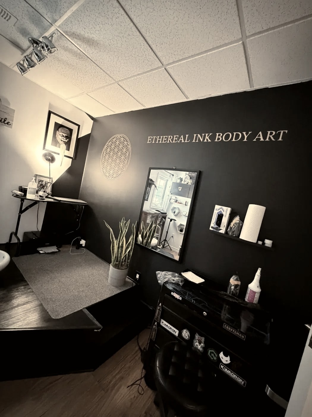 The tattooing room: the chair, the lamp, and the work surface beside it.
