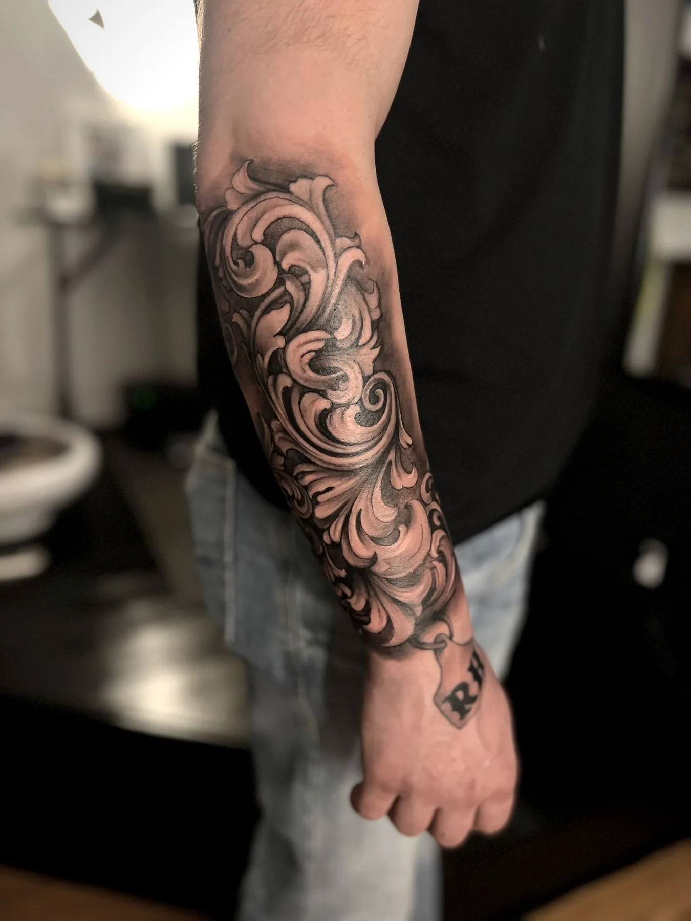 Ornamental filigree wrapping a forearm in black and grey.